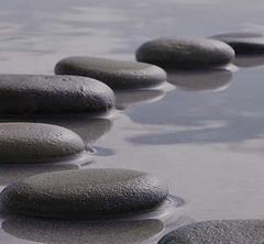 Round river stones on top of shallow water