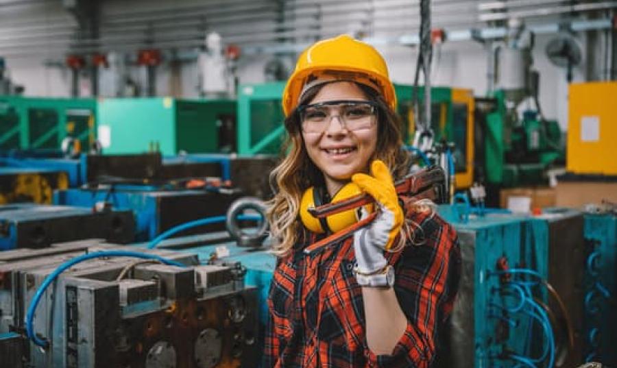 woman in hard hat holding a tool